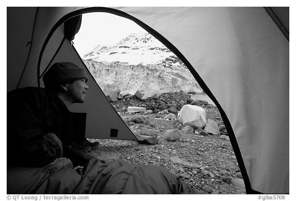 Visitor in  tent looking outside to Lamplugh Glacier. Glacier Bay National Park, Alaska