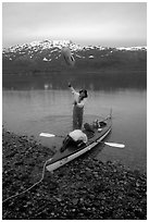 Kayaker unloading the kayak by throwing stuff sacks out. Glacier Bay National Park, Alaska (black and white)