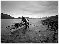 Kayaker getting into the kayak,  Muir Inlet. Glacier Bay National Park, Alaska (black and white)