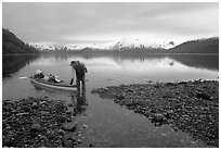 Kayaker standing in Scidmore Bay next to a shallow tidal channel. Glacier Bay National Park, Alaska (black and white)