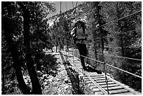 Crossing a river on a suspension footbridge. Kings Canyon National Park, California (black and white)