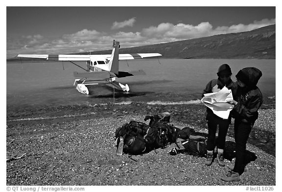 Backpackers dropped off by floatplane on Lake Turquoise orient themselves on the map. Lake Clark National Park, Alaska