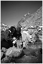 Hikers filing up a water container with a filter. Lake Clark National Park, Alaska (black and white)