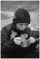 Backpacker eating camp food. Lake Clark National Park, Alaska (black and white)