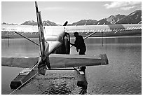 Pilot standing on floats of Floatplane, Twin Lakes. Lake Clark National Park, Alaska (black and white)