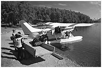 Backpackes being unloaded from floatplane to a trailer in Port Alsworth. Lake Clark National Park, Alaska (black and white)