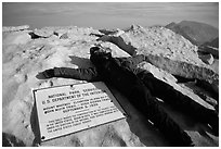Hiker laying exhausted on Mt Whitney summit sign. Sequoia National Park, California (black and white)