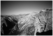 Hiker standing on top of Half-Dome, overlooking Tenaya Canyon. Yosemite National Park, California (black and white)
