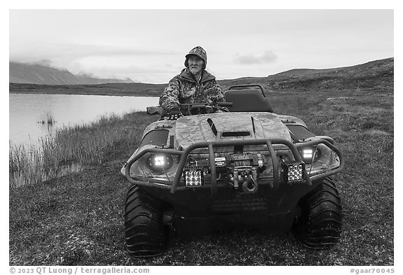 Nunamiut man driving all-terrain vehicle. Gates of the Arctic National Park (black and white)