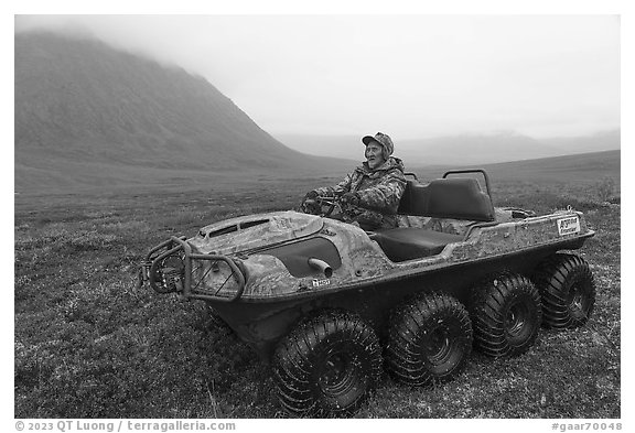 Nunamiut man driving eight-wheeled all-terrain vehicle. Gates of the Arctic National Park (black and white)