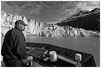 Captain guiding boat near Lamplugh glacier. Glacier Bay National Park, Alaska, USA. (black and white)