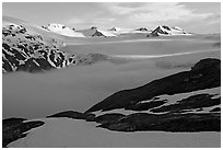 Low clouds, partly melted snow cover, and mountains. Kenai Fjords National Park, Alaska, USA. (black and white)