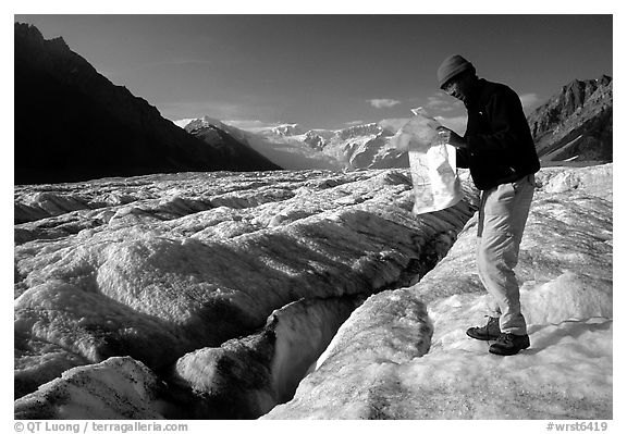 Hiker checks map on Root Glacier. Wrangell-St Elias National Park (black and white)