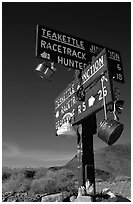 Tea kettle Junction sign, adorned with tea kettles. Death Valley National Park, California, USA. (black and white)