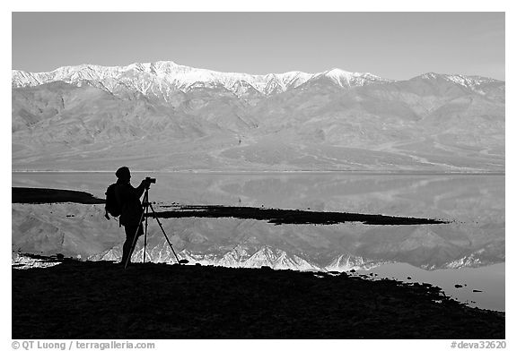 Photographer and Panamint range reflected in a seasonal lake, early morning. Death Valley National Park (black and white)