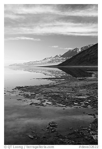 Black mountain reflections in flooded Badwater basin, early morning. Death Valley National Park, California, USA.