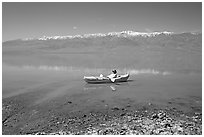 Kayaker near shore in Manly Lake. Death Valley National Park, California, USA. (black and white)