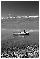 Salt formations, kayaker, and Panamint range. Death Valley National Park, California, USA. (black and white)