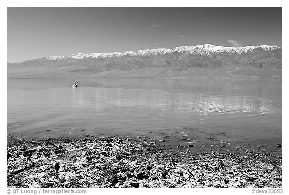 Salt formations, kayaker in a distance, and Panamint range. Death Valley National Park (black and white)