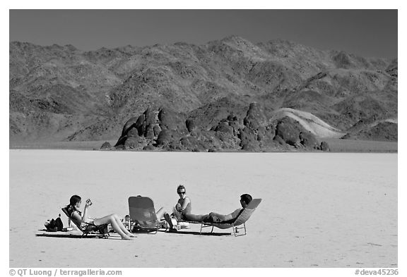 Tourists sunning themselves with beach chairs on the Racetrack. Death Valley National Park (black and white)