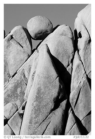 Spherical boulder jammed on top of triangular boulders, Jumbo rocks. Joshua Tree National Park, California, USA.
