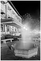 Fountain with thermal steam outside Fordyce Bath at night. Hot Springs National Park, Arkansas, USA. (black and white)