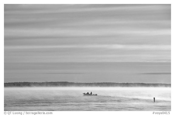 Boaters in fog, early morning, Kabetogama lake. Voyageurs National Park, Minnesota, USA.
