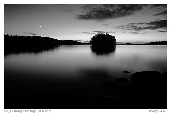 Sunset with moon on island on Kabetogama Lake near Ash river. Voyageurs National Park, Minnesota, USA.