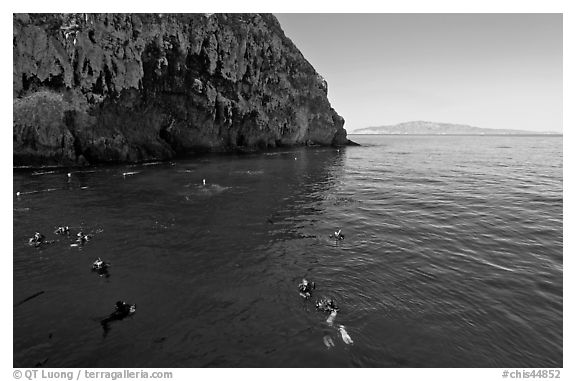 Divers, emerald waters, and steep cliffs, Annacapa island. Channel Islands National Park, California, USA.