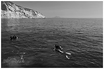 Scuba divers on ocean surface, Santa Cruz Island. Channel Islands National Park, California, USA. (black and white)
