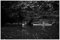 Two kayakers in sea cave with low ceiling, Santa Cruz Island. Channel Islands National Park ( black and white)