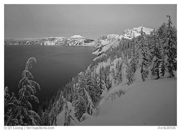 Snow-covered rim and trees, lake and mountains, dusk. Crater Lake National Park (black and white)