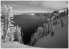 Snow-covered trees and dark lake waters. Crater Lake National Park, Oregon, USA. (black and white)
