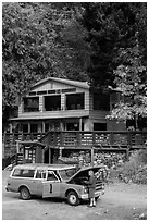 Man fixing old car in front of North Cascades Lodge, Stehekin, North Cascades National Park Service Complex.  ( black and white)