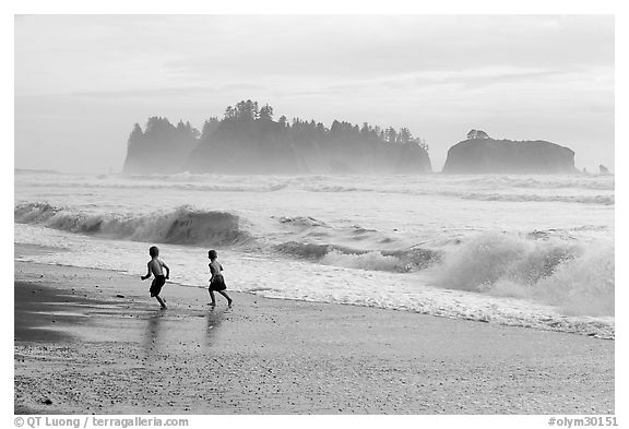 black and white photos of children. Children running along surf,