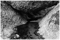 Creek flowing under boulder. Pinnacles National Park, California, USA. (black and white)