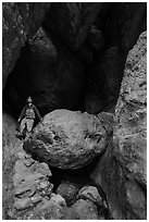 Man with headlamp looking up in Balconies Cave. Pinnacles National Park, California, USA. (black and white)