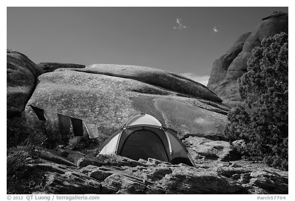 Tent with prayer flags amongst sandstone rocks. Arches National Park (black and white)