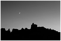 Crescent moon at sunset and Doll House spires. Canyonlands National Park, Utah, USA. (black and white)