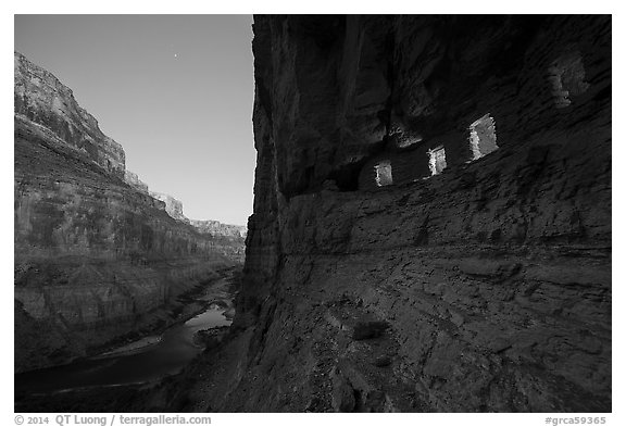 Ancient Nankoweap granaries with windows lit and Colorado River at dusk. Grand Canyon National Park (black and white)