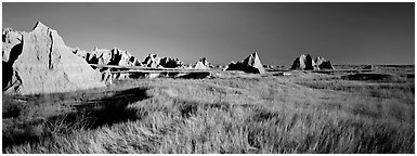 Badlands raising in tall grass prairie landscape. Badlands National Park (Panoramic black and white)
