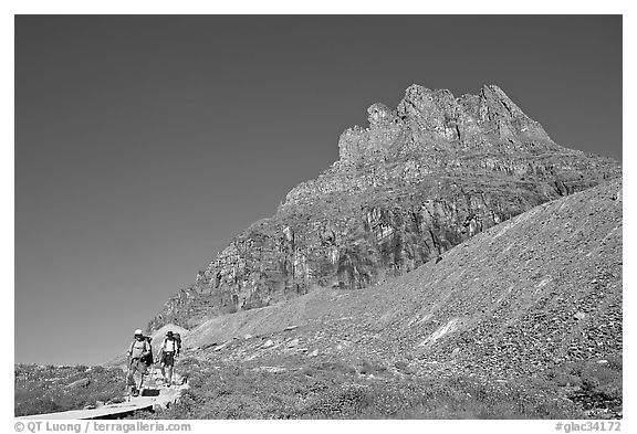 Two backpackers descending on trail near Logan Pass. Glacier National Park, Montana, USA.