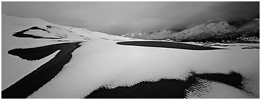 Snow-covered dune landscape and mountains at dawn. Great Sand Dunes National Park (Panoramic black and white)