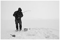 Ice fisherman standing next to hole, Jackson Lake. Grand Teton National Park ( black and white)