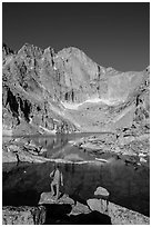 Hiker standing near Chasm Lake, looking at Longs peak. Rocky Mountain National Park, Colorado, USA. (black and white)