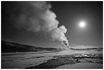 Old Faithful Geyser eruption and moon. Yellowstone National Park, Wyoming, USA. (black and white)