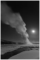 Night view of Old Faithful Geyser in winter with full moon. Yellowstone National Park, Wyoming, USA. (black and white)