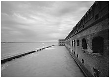 Fort Jefferson massive brick wall overlooking the ocean, cloudy weather. Dry Tortugas National Park, Florida, USA. (black and white)