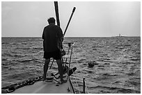 Sailor getting ready to hook mooring buoy near Loggerhead Key. Dry Tortugas National Park, Florida, USA. (black and white)