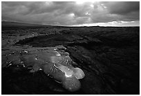 Flowing lava and rain clouds at dawn. Hawaii Volcanoes National Park, Hawaii, USA. (black and white)